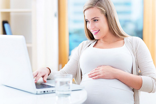 kobieta w ciąży przed komputerem